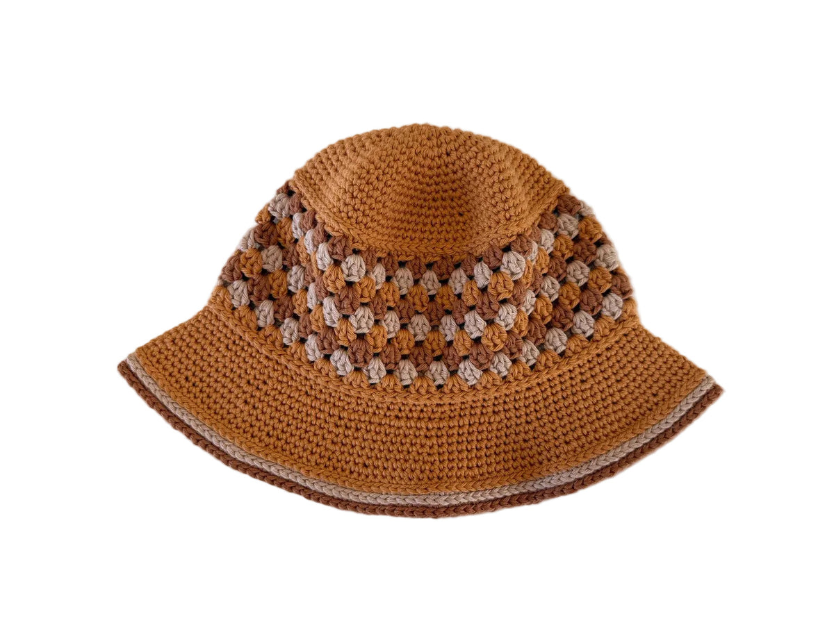 A gold/brown crocheted bucket hat on a white background