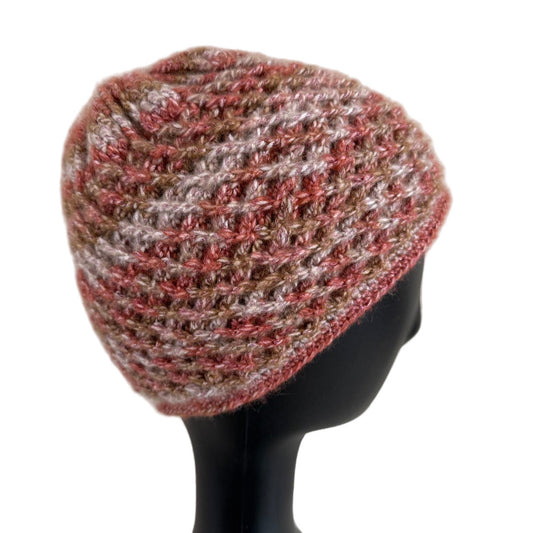 A handmade crochet spirograph beanie in red, brown, and beige shades displayed on a mannequin head.