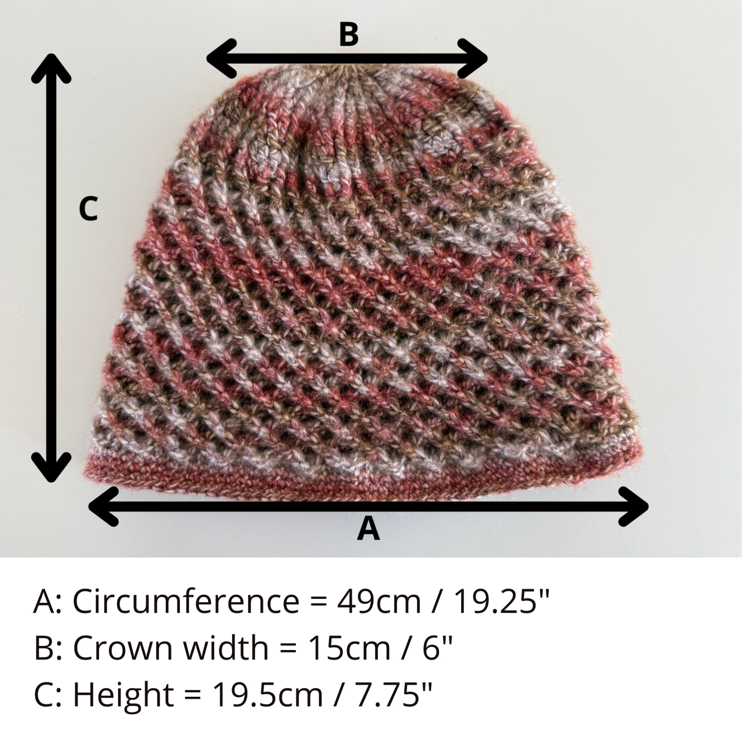 A handmade crochet spirograph beanie in red, brown, and beige shades showing size.