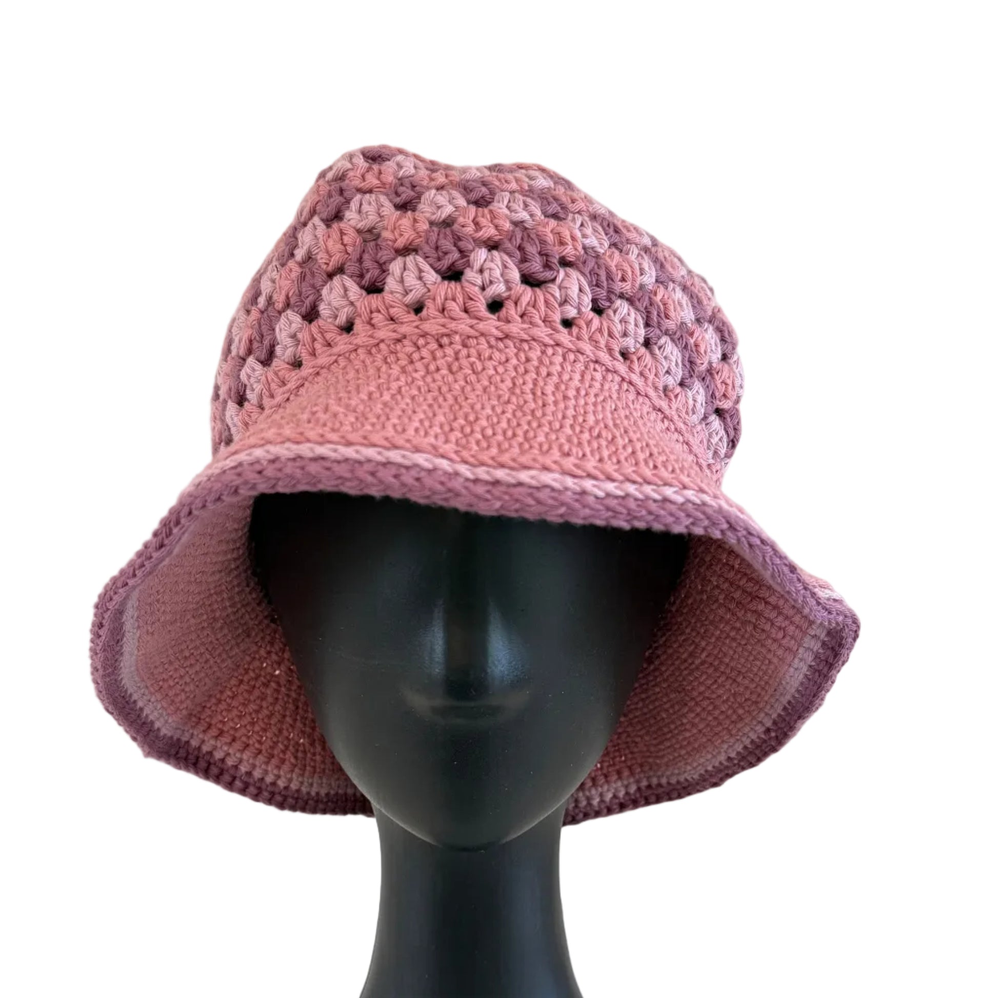 A mauve-rose crocheted bucket hat displayed on a black mannequin head on a white background