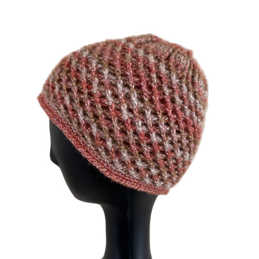 A handmade crochet spirograph beanie in red, brown, and beige shades displayed on a mannequin head.