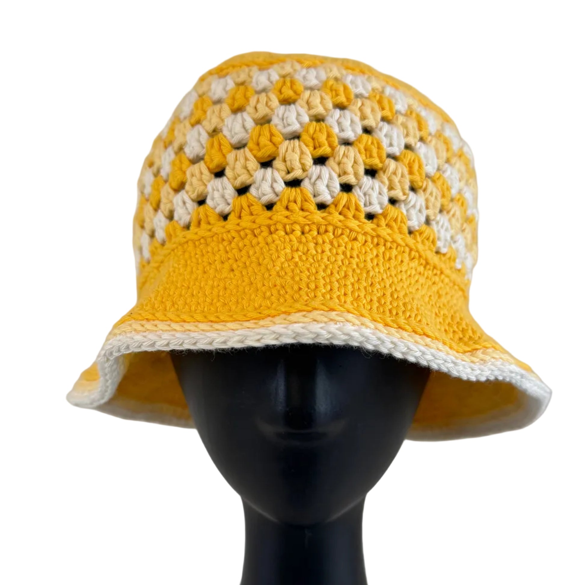 A yellow crocheted bucket hat displayed on a black mannequin head on a white background